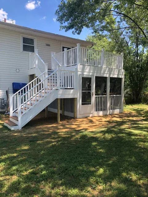 A white deck with a white railing and stairs.