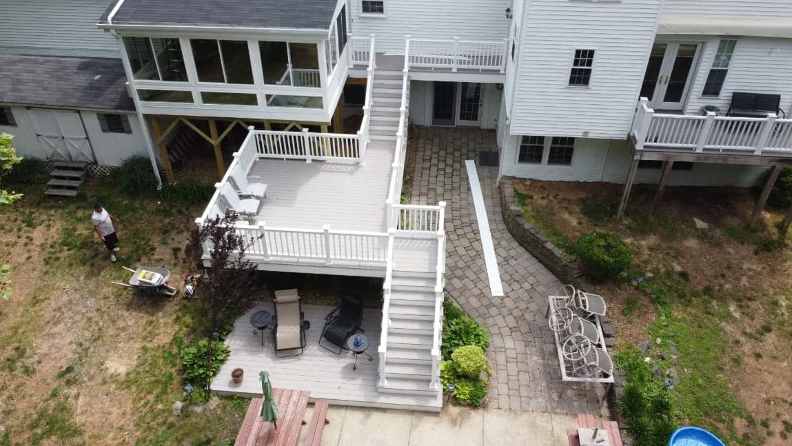 An aerial view of a large white deck in a backyard.
