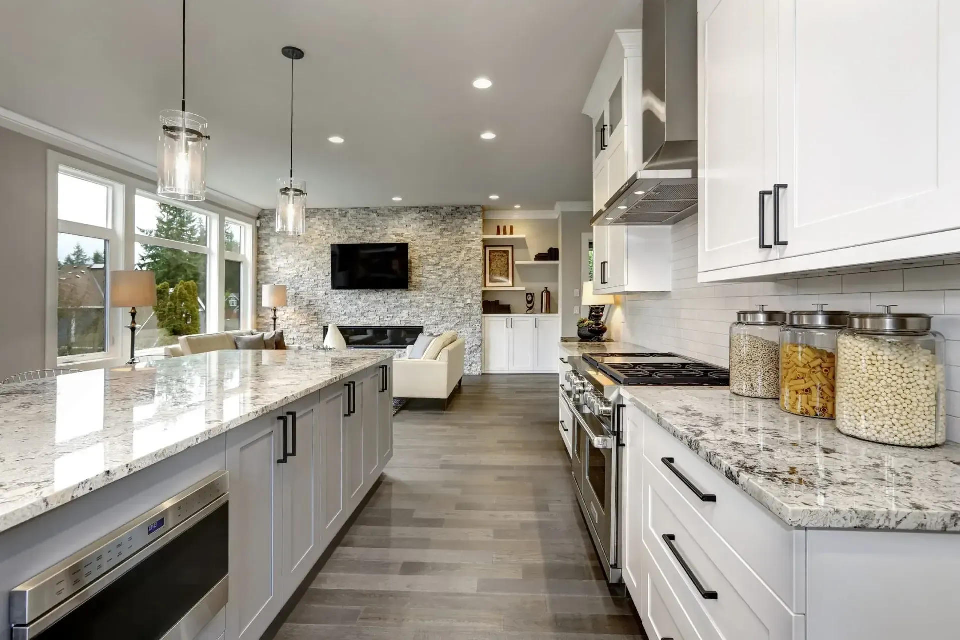 A bright, modern space showcasing a Maryland kitchen remodel featuring white cabinetry, a large granite island, and an open layout that flows into a beautifully updated living area.
