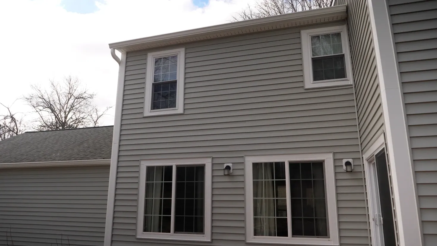 A photo of a light gray colonial-style house.