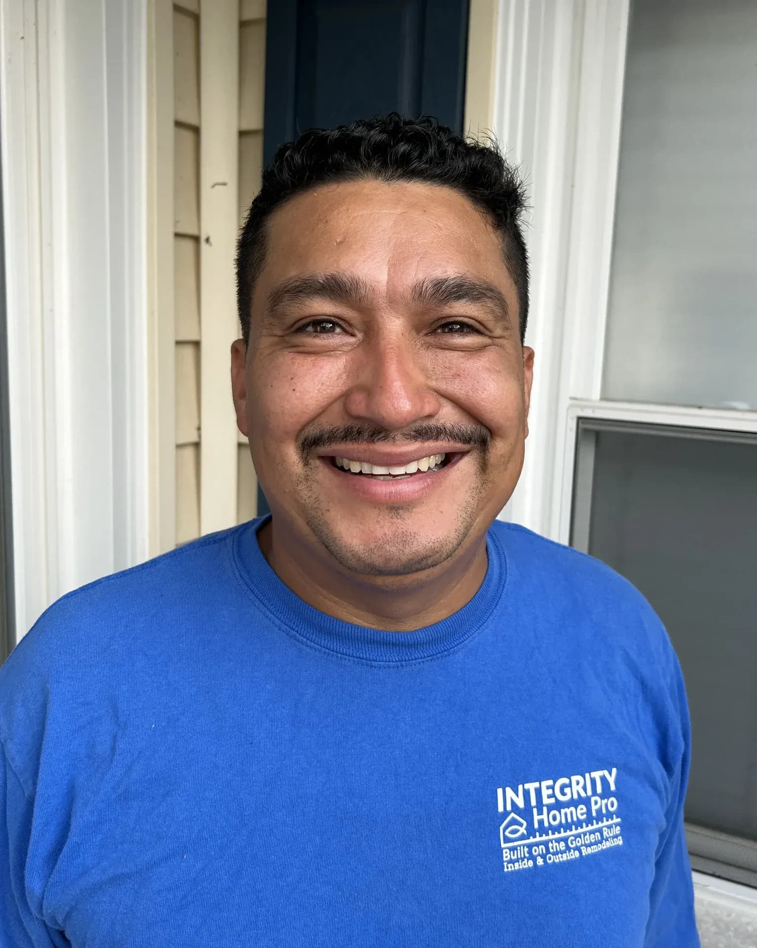 A headshot of a team member in a blue Integrity Home Pro t-shirt.
