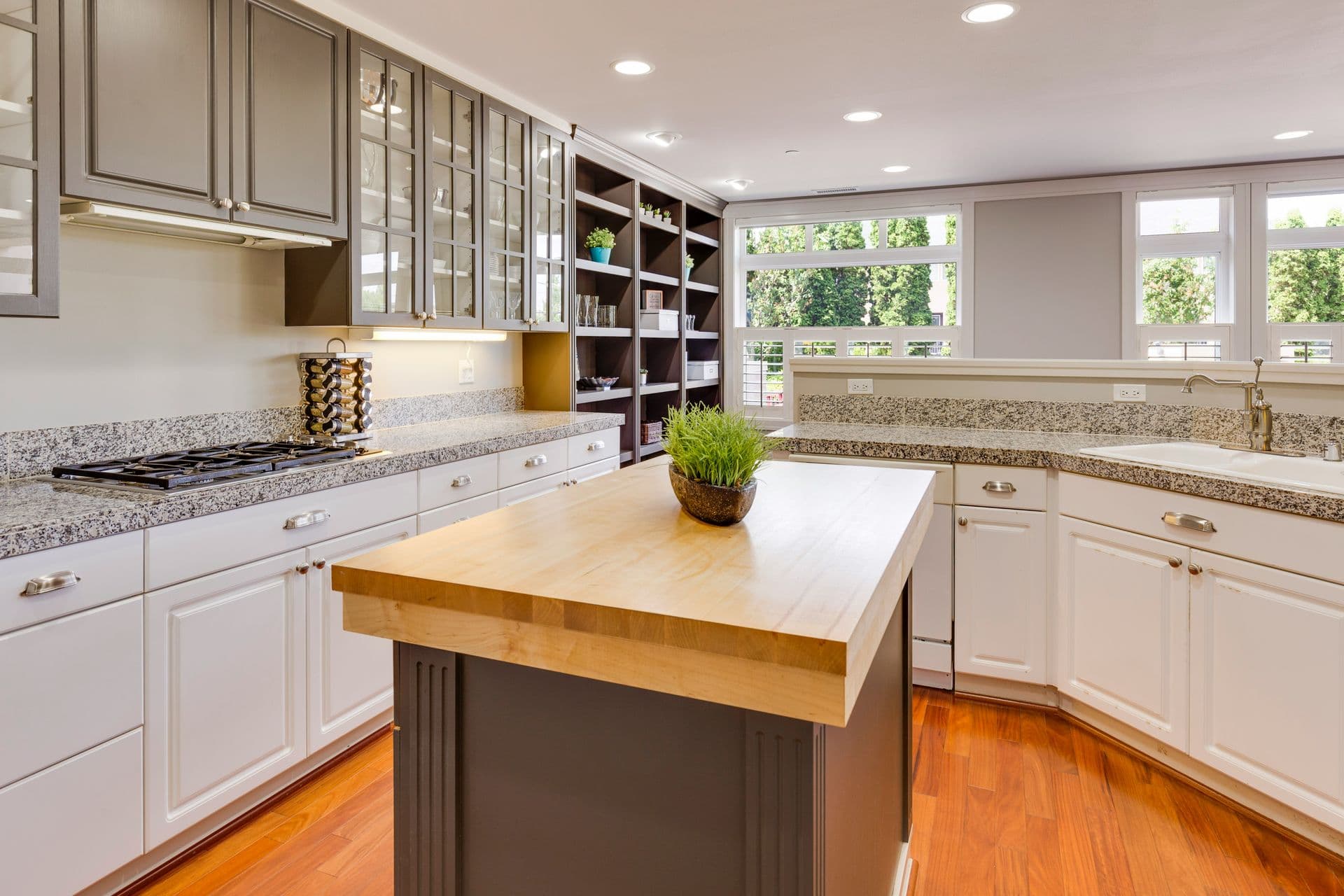 A bright and spacious remodeled kitchen featuring a natural wood island, granite countertops, and modern cabinetry—an inviting example of quality kitchen renovation work in Maryland.