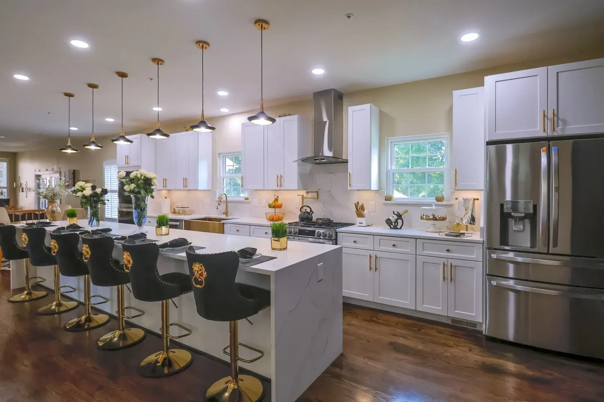 A luxury Maryland kitchen remodel with white shaker cabinets, gold hardware, a spacious island, and elegant pendant lighting designed for both beauty and functionality.