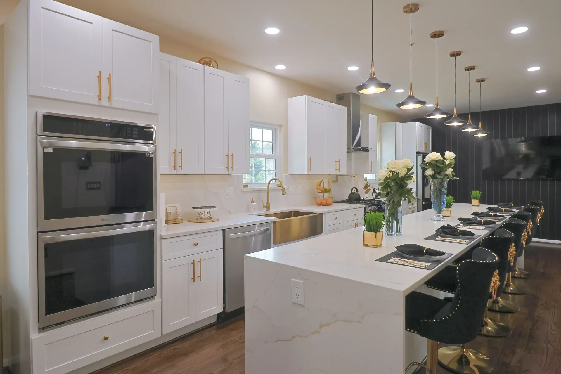 A view of the kitchen with a double oven on the left and the island on the right.