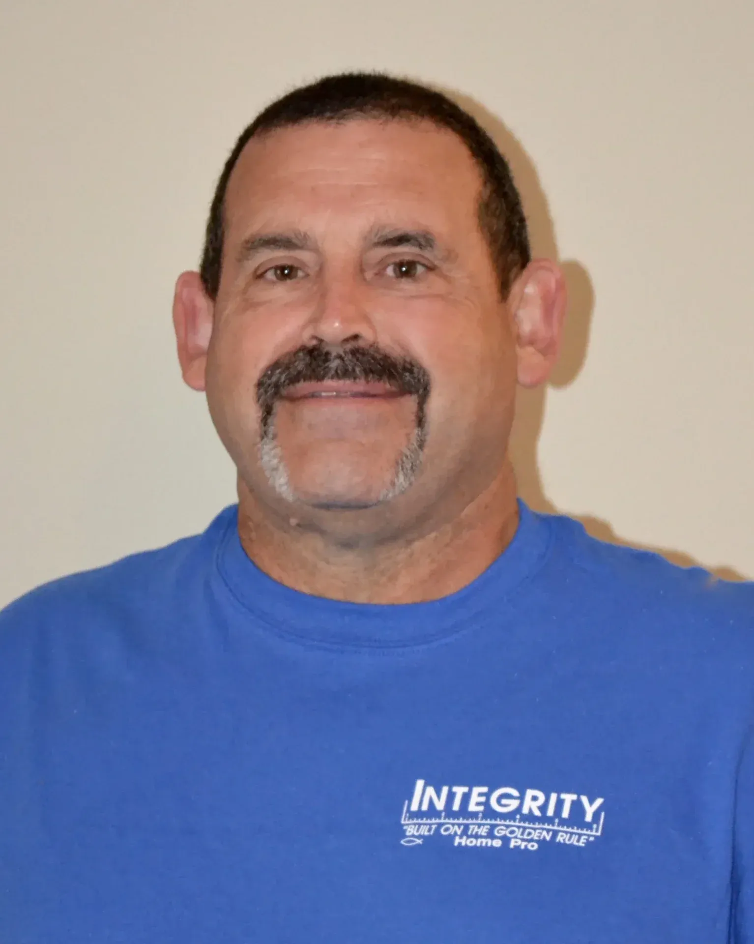A headshot of a team member in a blue Integrity Home Pro t-shirt.
