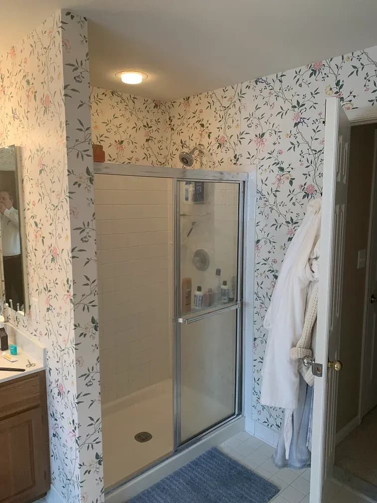 A photo of a shower with sliding glass doors.