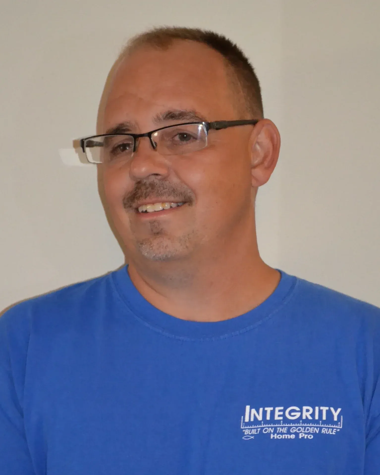 A headshot of a team member in a blue Integrity Home Pro t-shirt.